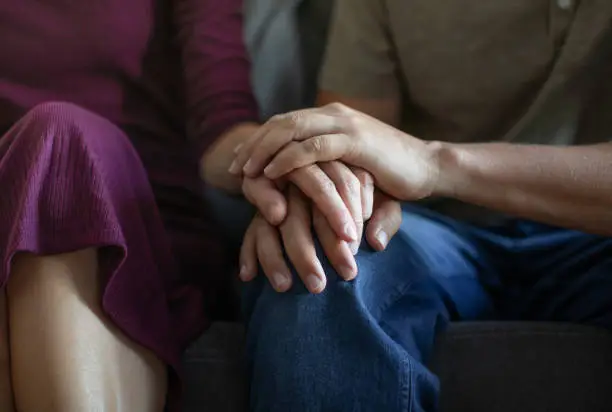 Two people's hands clasked, symbolizing connection in couples counseling